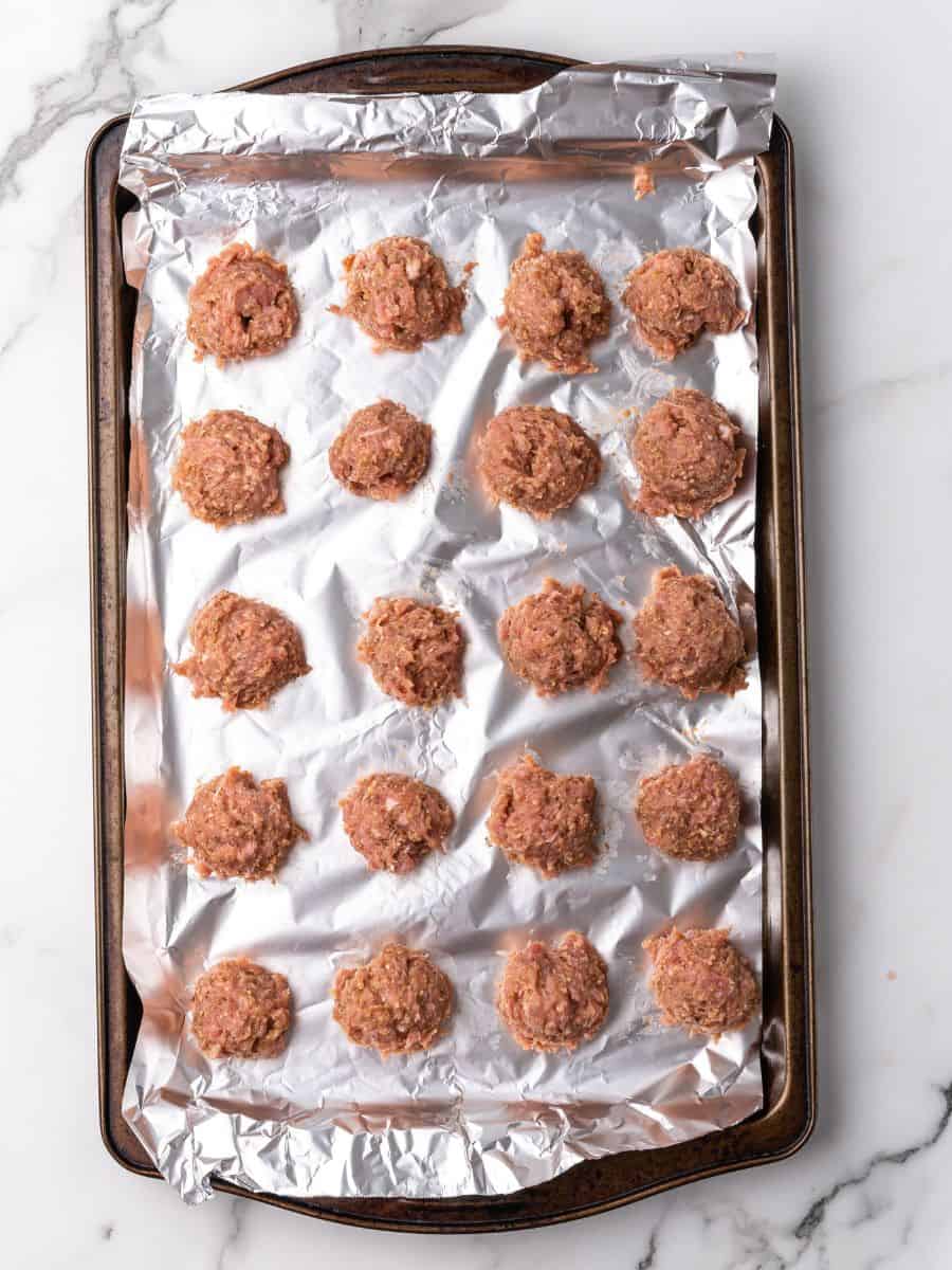 raw meatballs on a sheet pan.