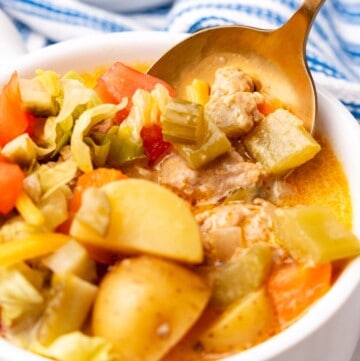 closeup of cheeseburger soup in a bowl with spoon.