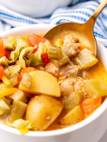 closeup of cheeseburger soup in a bowl with spoon.