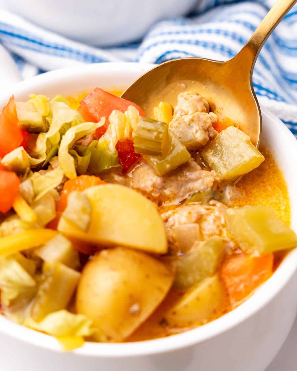 closeup of cheeseburger soup in a bowl with spoon.