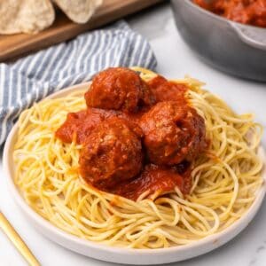 baked turkey meatballs on a plate of pasta.