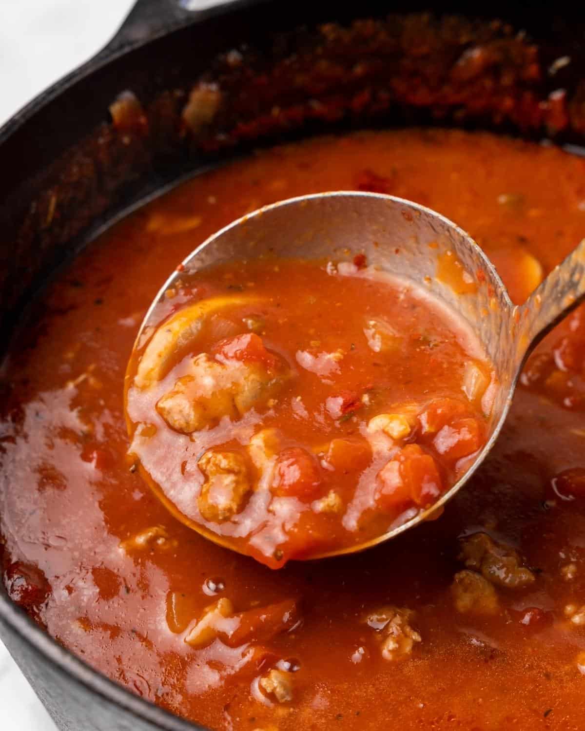 pizza soup in a ladle over the pot.