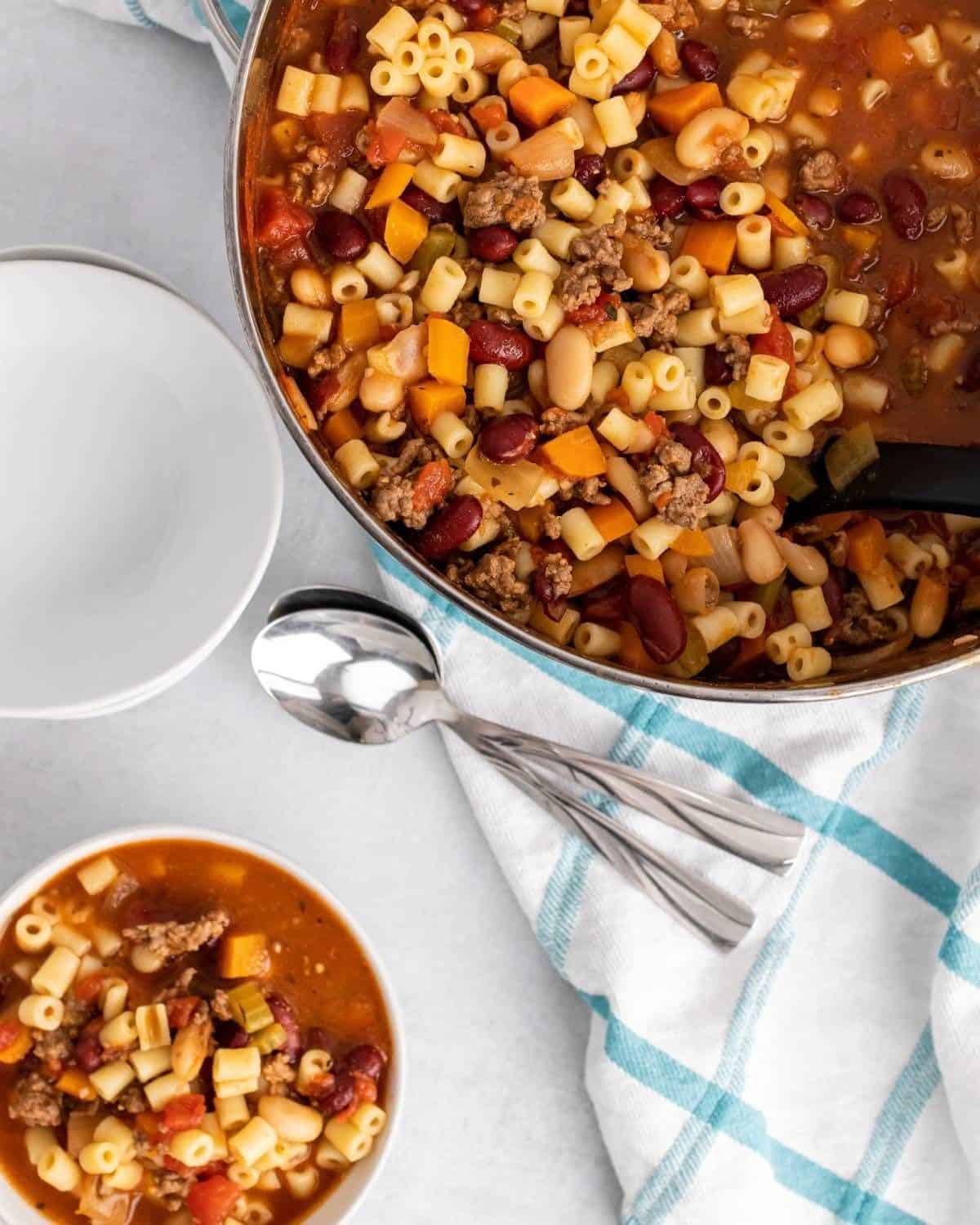 overhead picture of pasta fagioli in a bowl next to a pot.