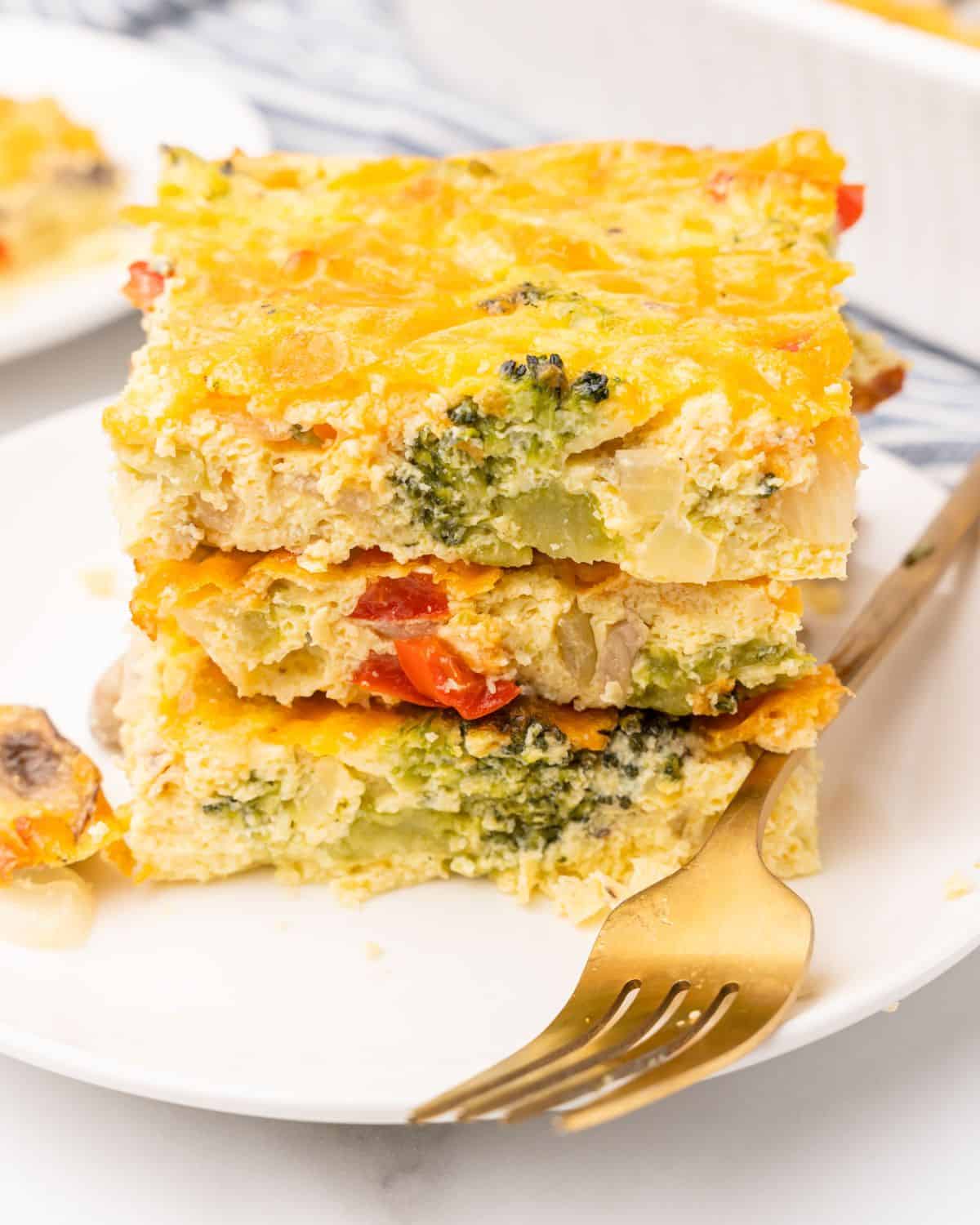 a plate with three pieces of veggie egg bake stack on top of each other.