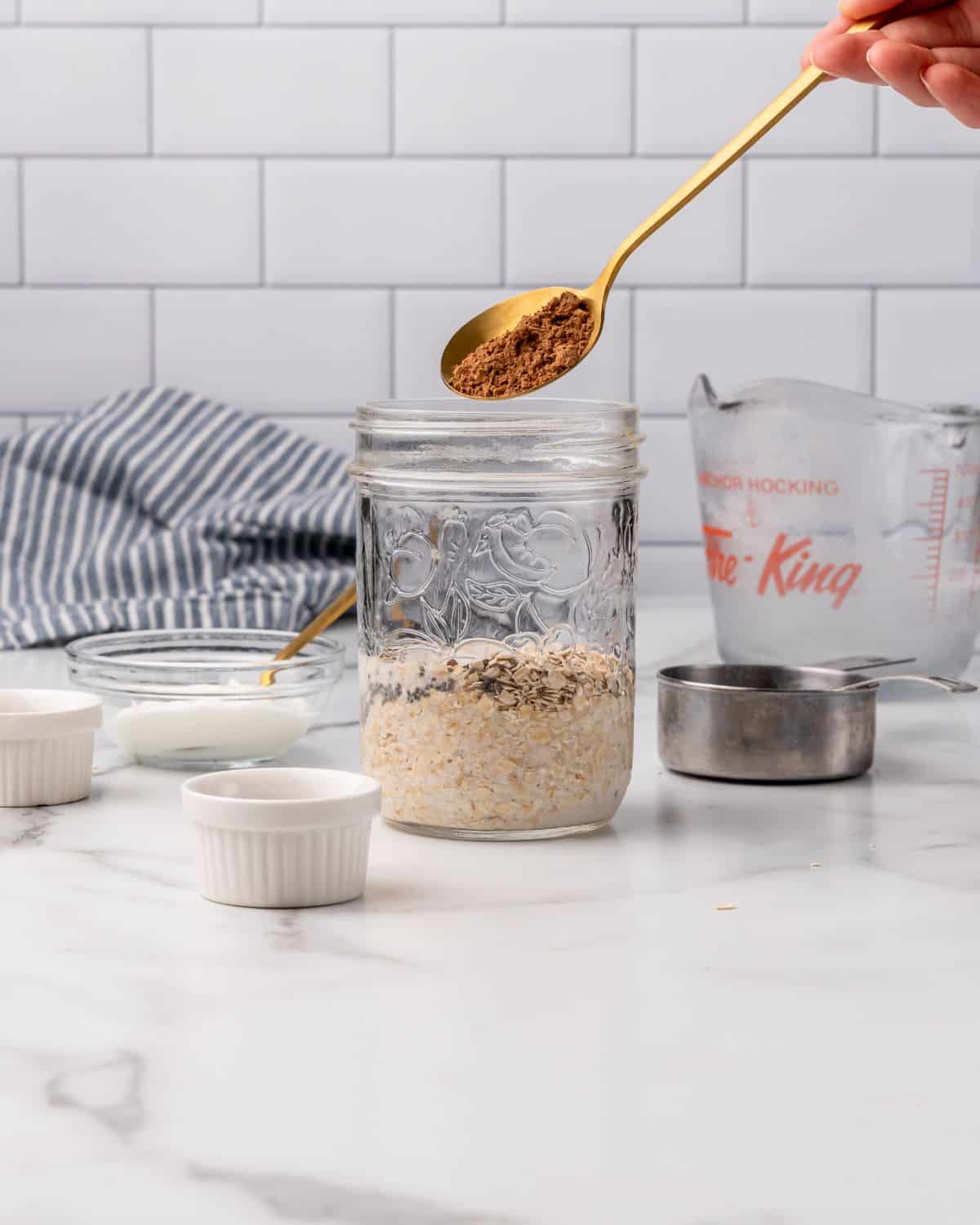 adding cacao powder into a mason jar.