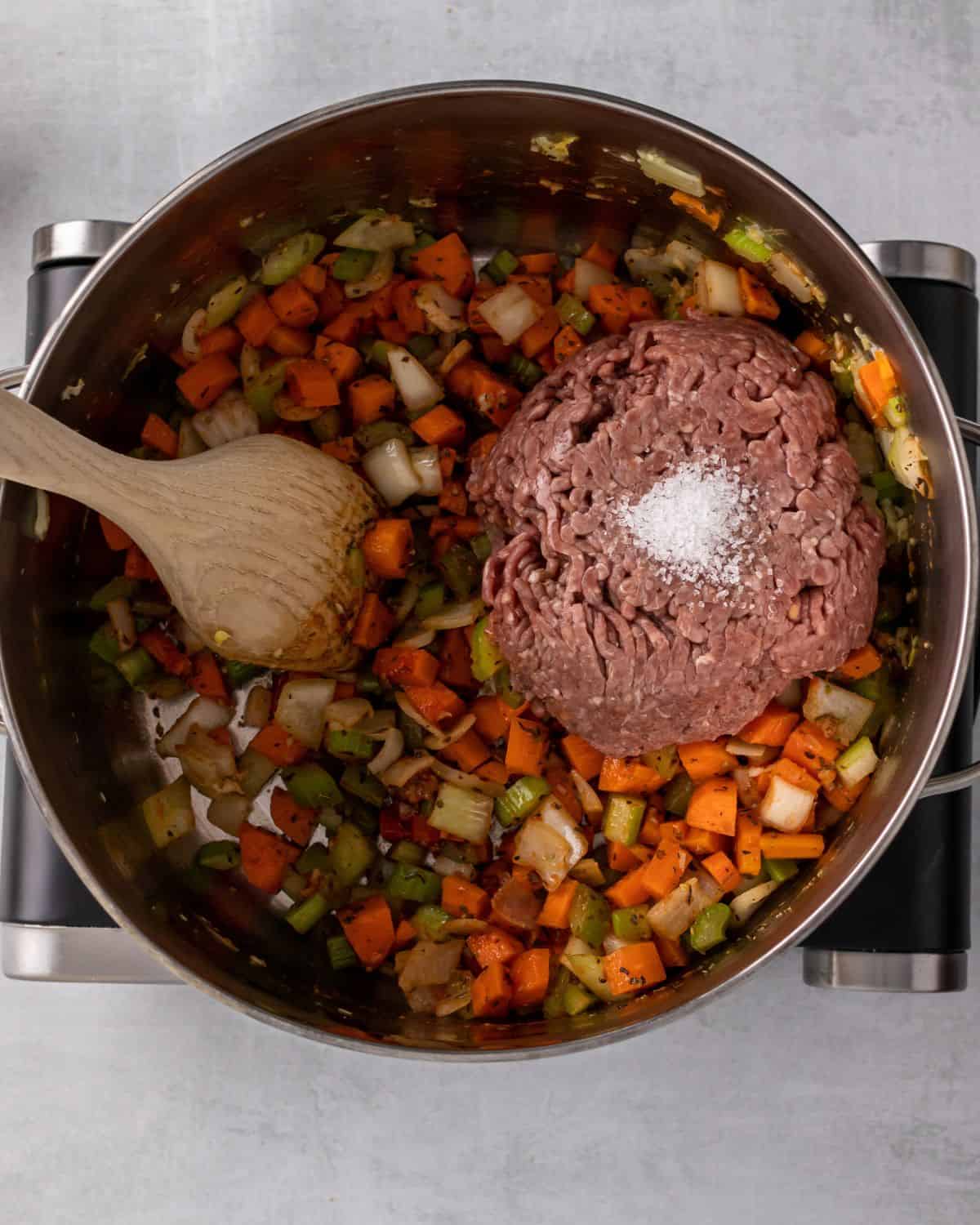 ground beef in the soup pot with veggies.