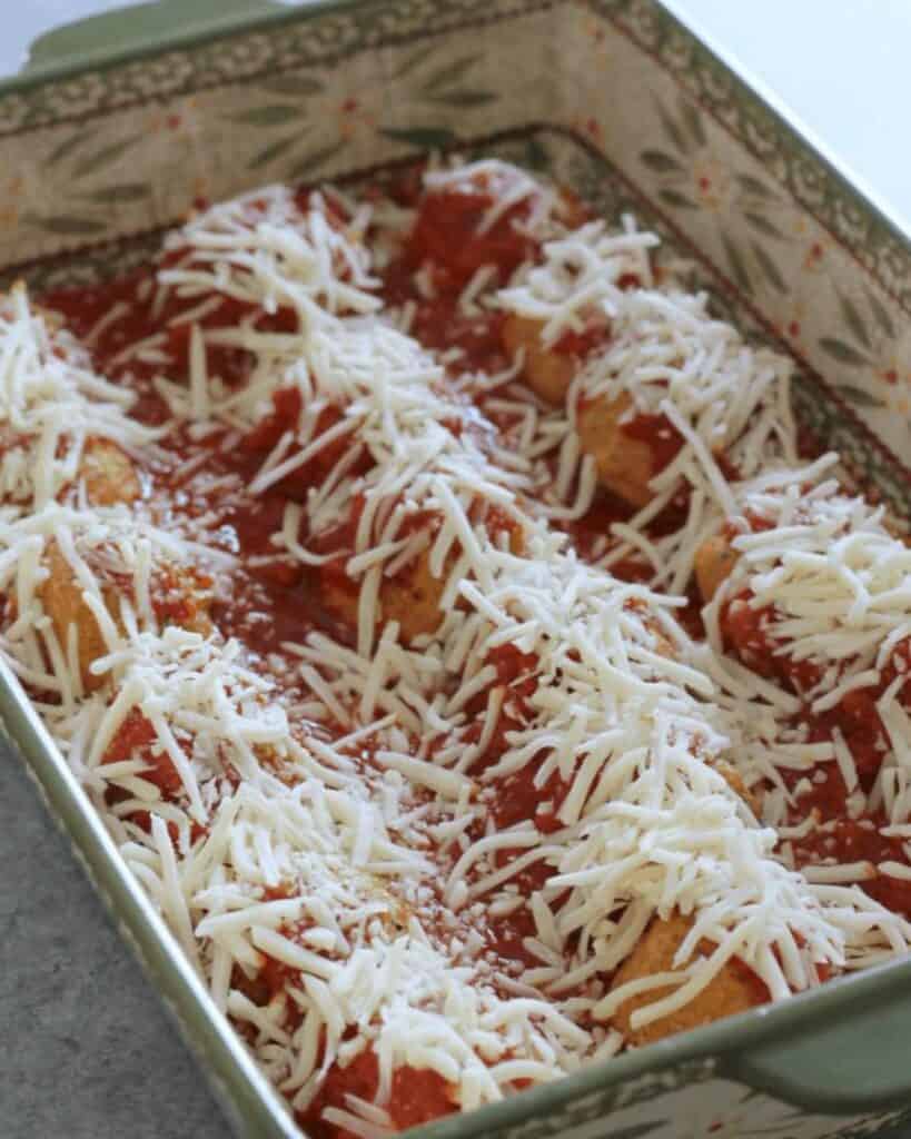 chicken parmesan meatballs with shredded mozzarella cheese on top.