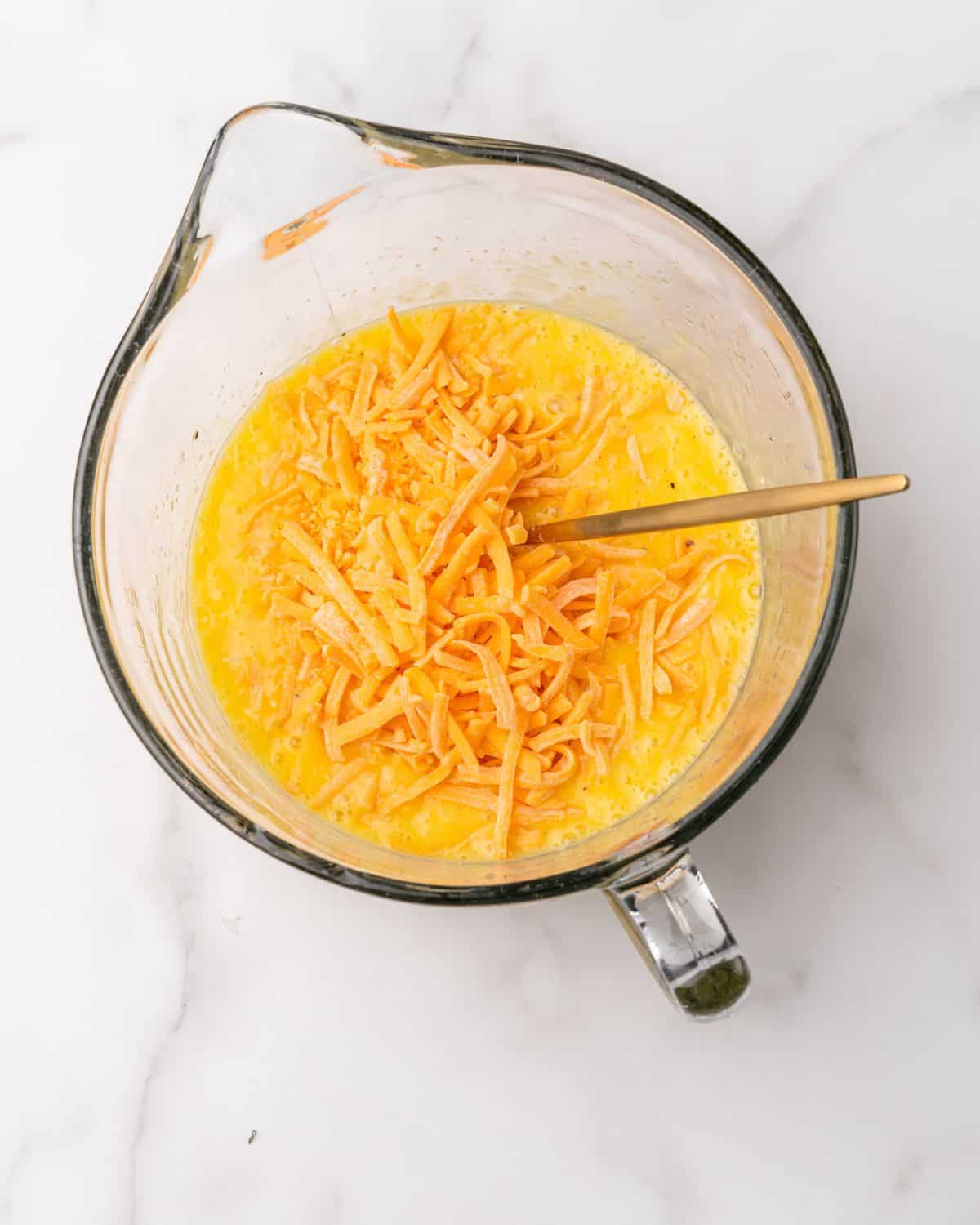 shredded cheese in the bowl with the egg mixture.