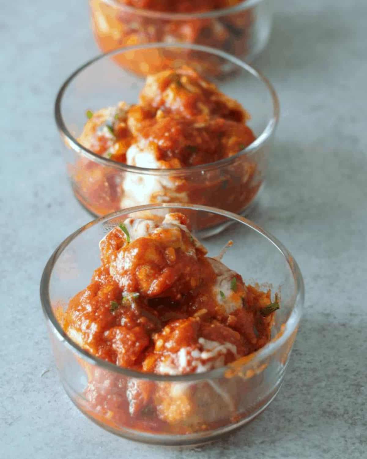 chicken parm meatballs in glass meal prep containers.