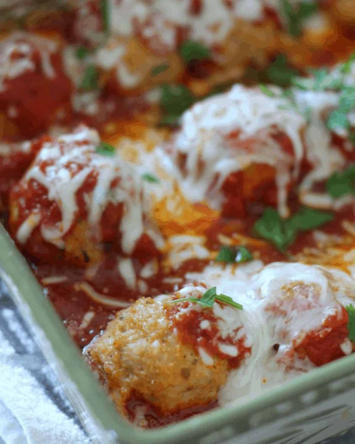 mozzarella cheese melted on the meatballs with herbs.