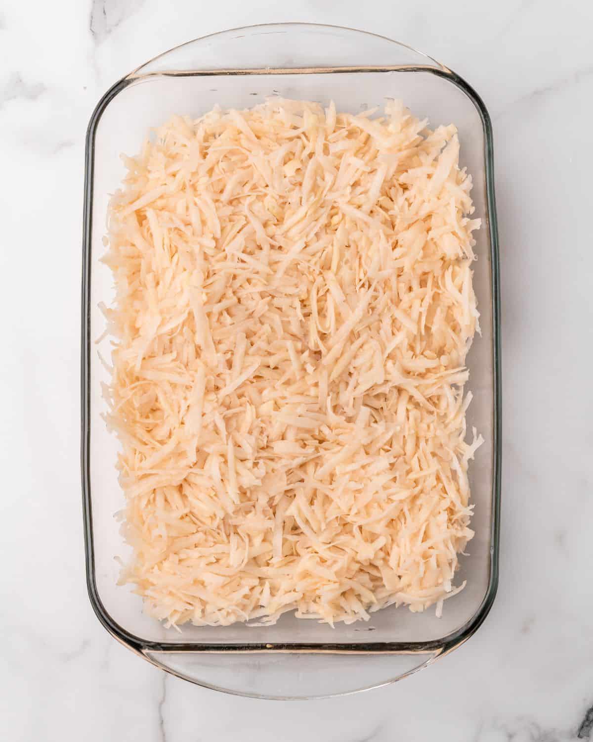 Overhead picture of shredded hash browns in a baking dish.