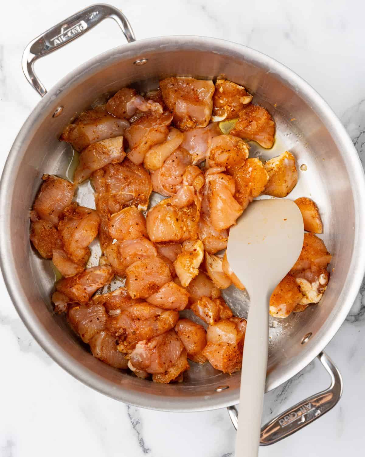 cajun chicken being cooked in a large pot.