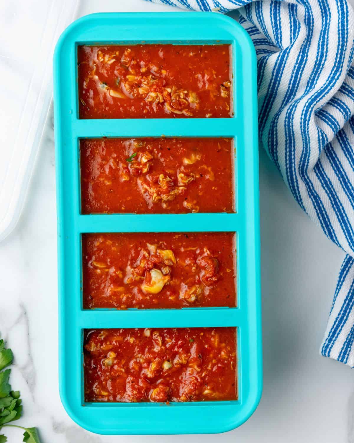 red clam sauce in a souper cube tray.