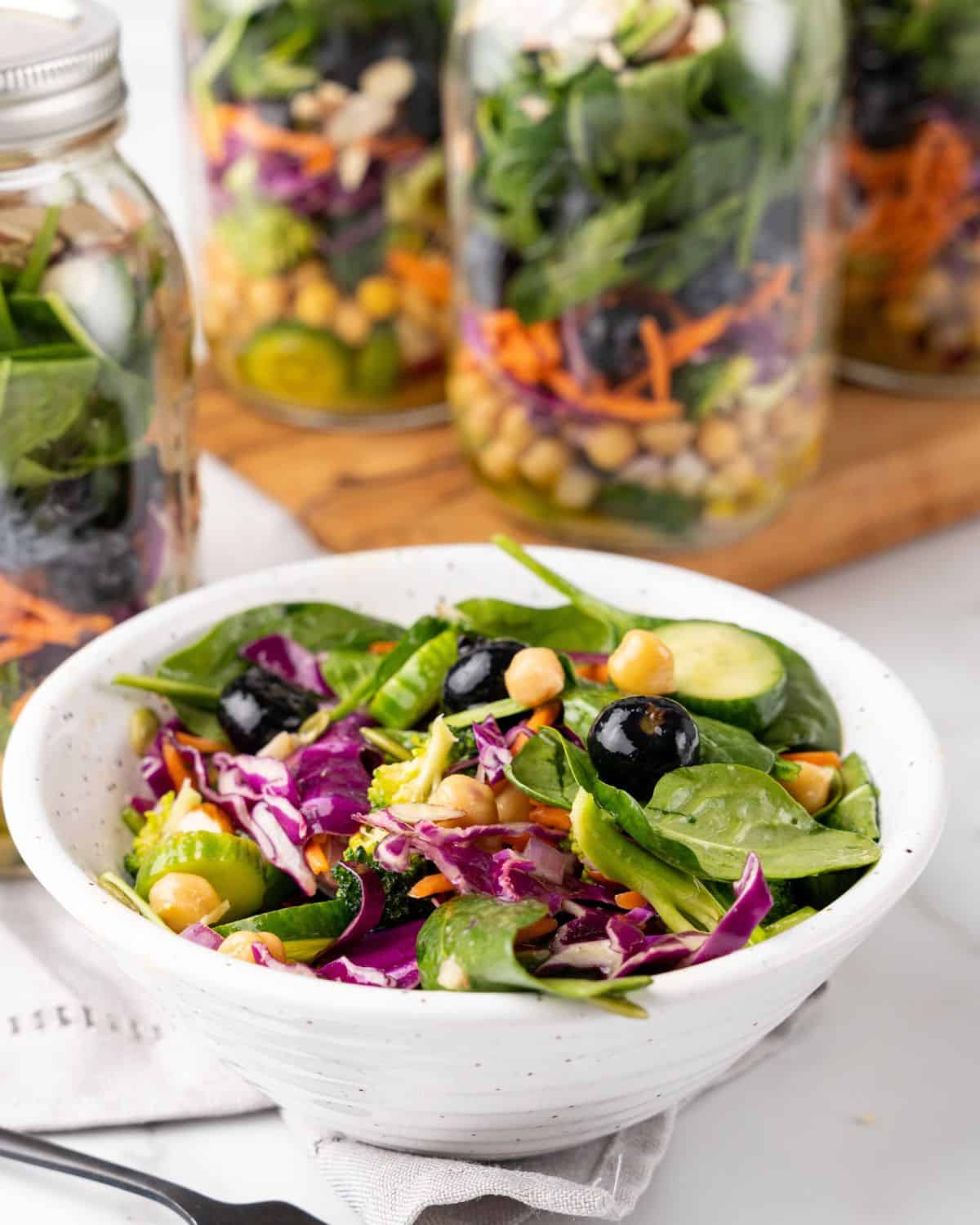 mason jar salad poured into a white bowl.