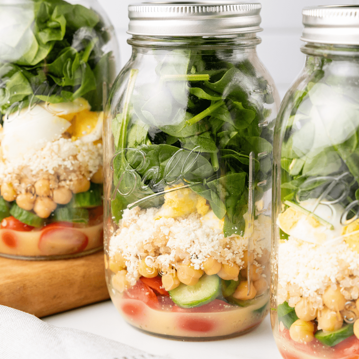 Protein Salad in a Jar Feature Image. Close up image on the salad layered into mason jars.