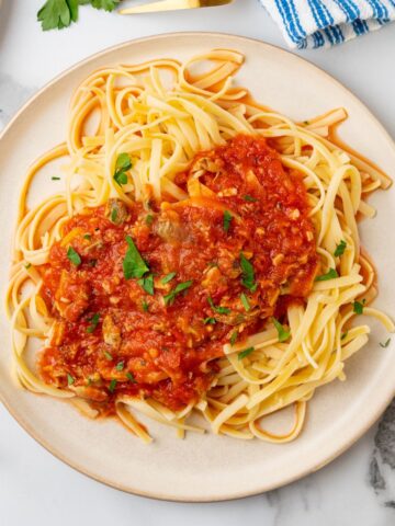 red clam sauce made with canned clams over linguine pasta.