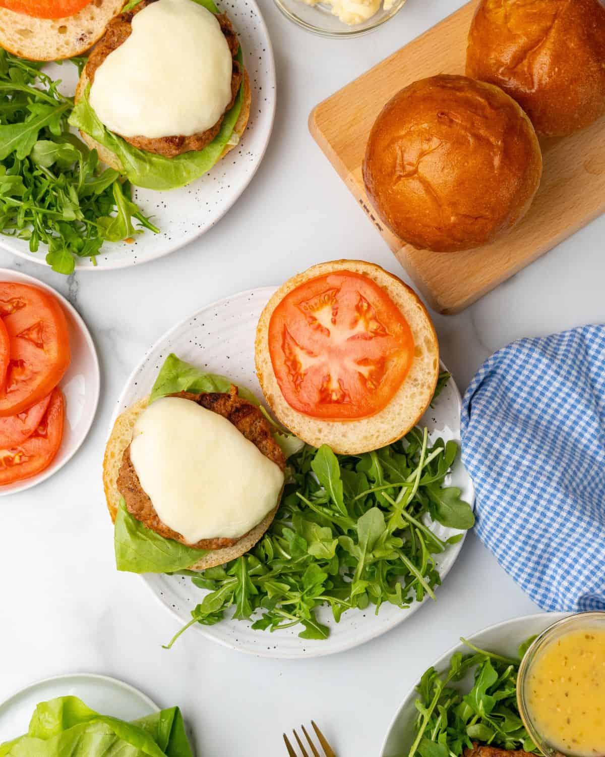 overhead picture of turkey burgers on roll with condiments.