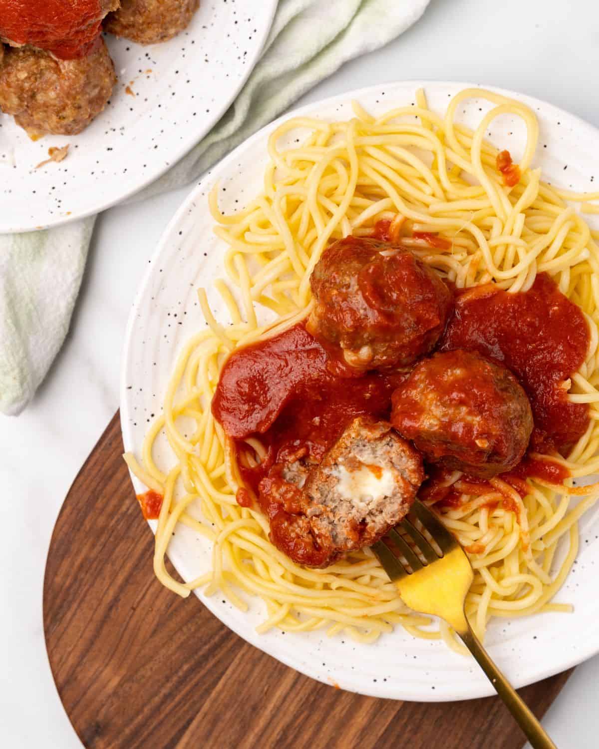stuffed mozzarella meatballs on top of pasta.