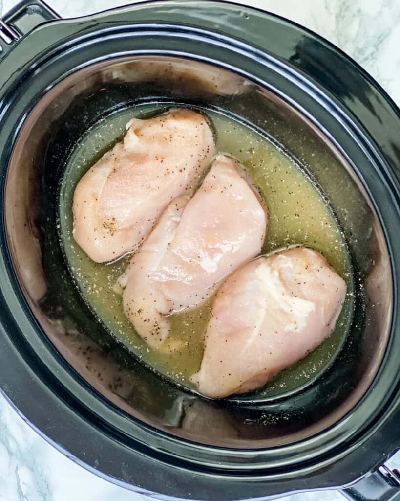 raw chicken breasts in the bottom of crockpot.