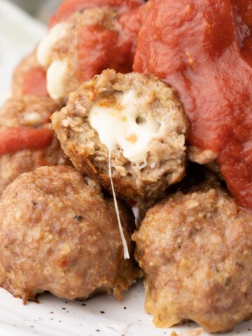 stuffed turkey meatballs on a plate with sauce.