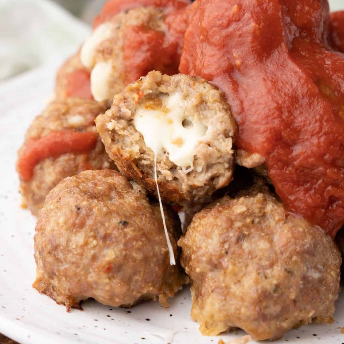 mozzarella stuffed meatballs on a plate.