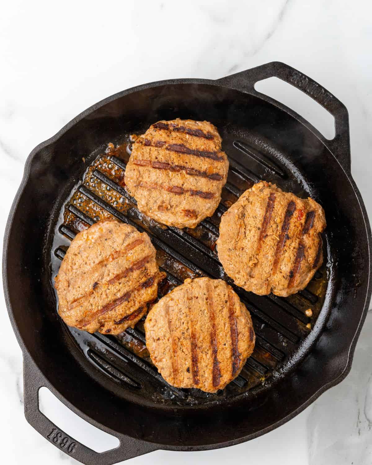 turkey patties cooking on a indoor grill pan.