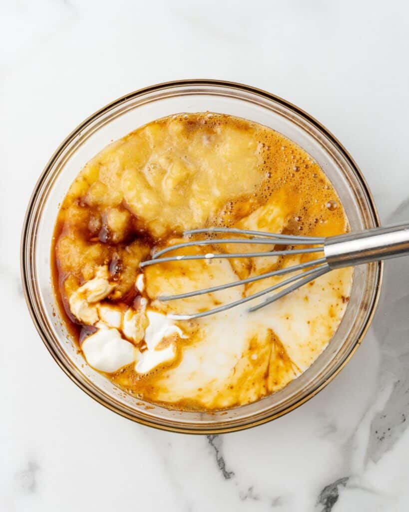 banana, greek yogurt, and milk mixed in a bowl.