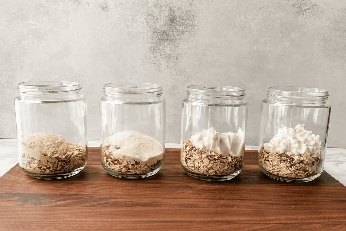 mason jars with rolled oats and different protein options in each one